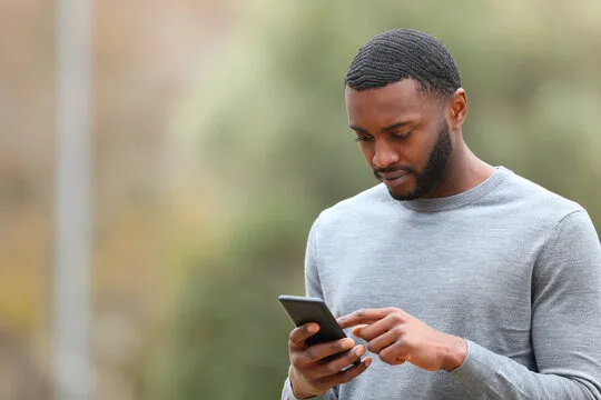 A person looking at his phone and reviewing P999 Game